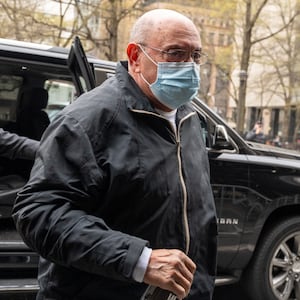 Allen Weisselberg, dressed in all black and wearing a surgical mask, walks into court.