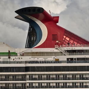 Passengers are seen on the upper deck as Carnival Pride, a Spirit-class cruise ship operated by Carnival Cruise Line, sails the Tagus River after leaving the Cruise Terminal on June 01, 2022 in Lisbon, Portugal.