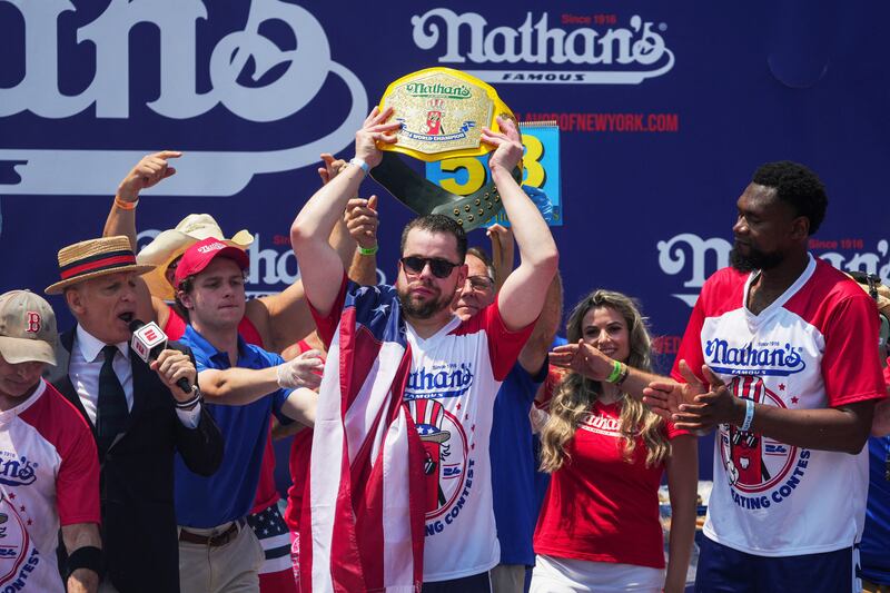 Patrick Bertoletti holds a trophy as he wins men's division of the 2024 Nathan's Famous Fourth of July International Hot Dog Eating Contest