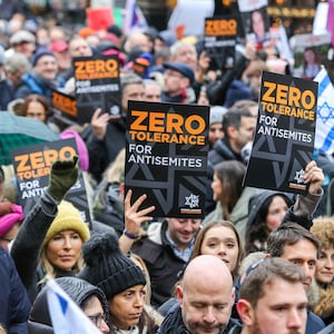 Protesters with placards and flags march on the street during the demonstration.