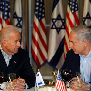 Then-U.S. Vice President Joe Biden sits with Israel's Prime Minister Benjamin Netanyahu before flags