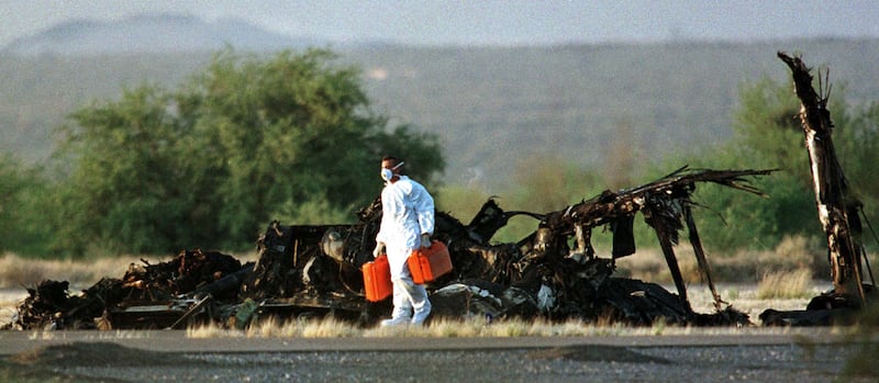 An investigator leaves the crash scene April 9, where a MV-22 tiltrotor Osprey aircraft crashed killing the 19 Marine personel on board at Avra Valley Regional Airport in Marana, Arizona April 8. 