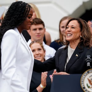 Vice President Kamala Harris standing at a podium with a student. 