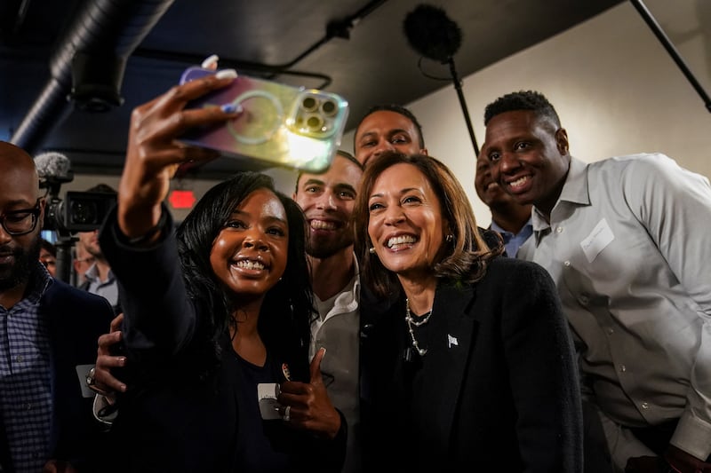 Kamala Harris poses for a group selfie during a campaign stop at an art gallery in Detroit, Michigan, on October 15, 2024.