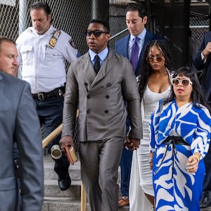 A photo of Jonathan Majors leaving court. 