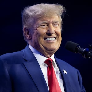 Donald Trump smiles on stage at a campaign event.