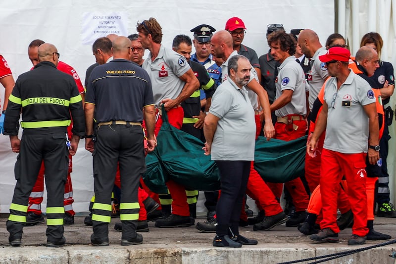 Authorities carry a green body bag