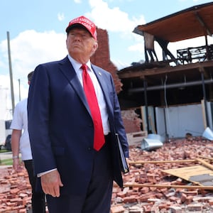 Former President Donald Trump listens to a question as he visits Chez What Furniture Store which was damaged during Hurricane Helene.