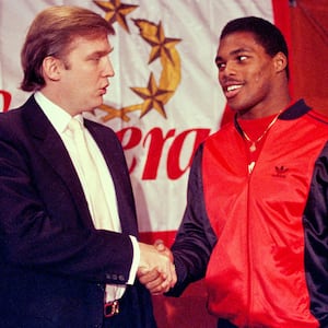 Then-New Jersey Generals owner Donald Trump shakes hands with Herschel Walker