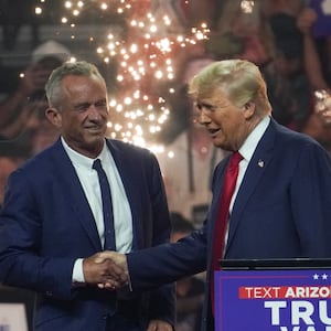 Donald Trump and Robert F. Kennedy Jr. shake hands on stage.