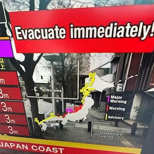 A warning message on a television screen asks people to evacuate immediately from an area after earthquakes hit Japan.