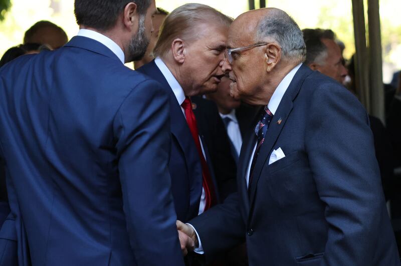 Donald Trump and Rudy Giuliani shake hands.