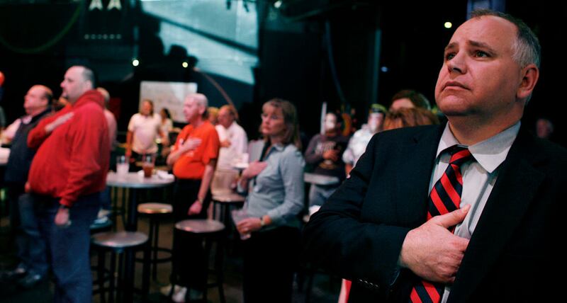 Then-congressional candidate Tim Walz stands for the national anthem while attending a meeting of Disabled American Veterans in Rochester, Minnesota.