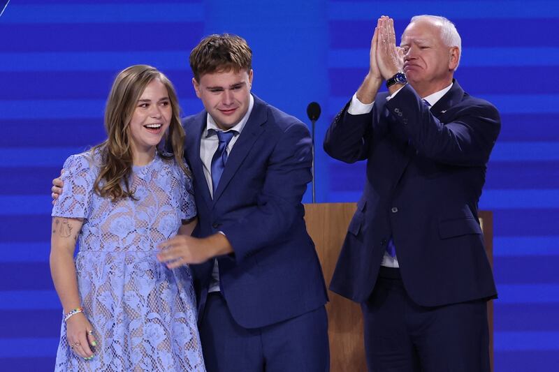 U.S. Democratic vice presidential nominee Tim Walz gestures next to his son Gus and his daughter Hope on Day 3 of the Democratic National Convention.