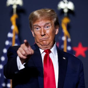 Donald Trump makes a face and points while on stage at a campaign event.