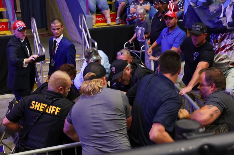 Law enforcement officers detain a rallygoer who tried to climb onto the press riser during a campaign event held by Republican presidential nominee Donald Trump in Johnstown, Pennsylvania, on August 30, 2024.