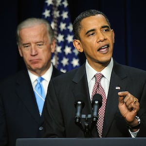 Then-President Barack Obama (R) speaks as Vice President Joe Biden looks on.