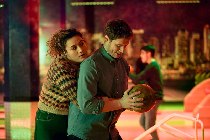 Rose Matafeo with her arms around Lorne MacFayden while he holds a bowling ball in ‘Starstruck’