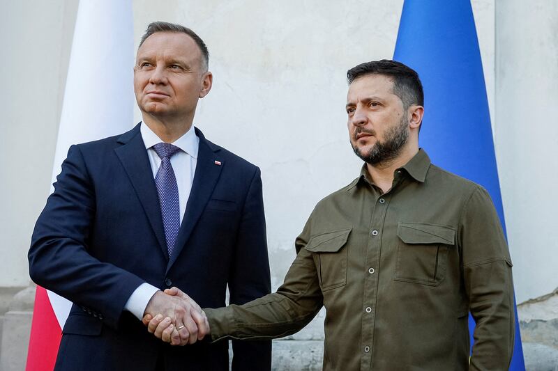 A photo of Ukrainian President Volodymyr Zelenskyy and Polish President Andrzej Duda shaking hands in July 2023.