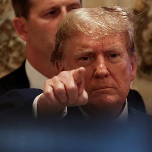 Donald Trump points at a camera at a campaign event.