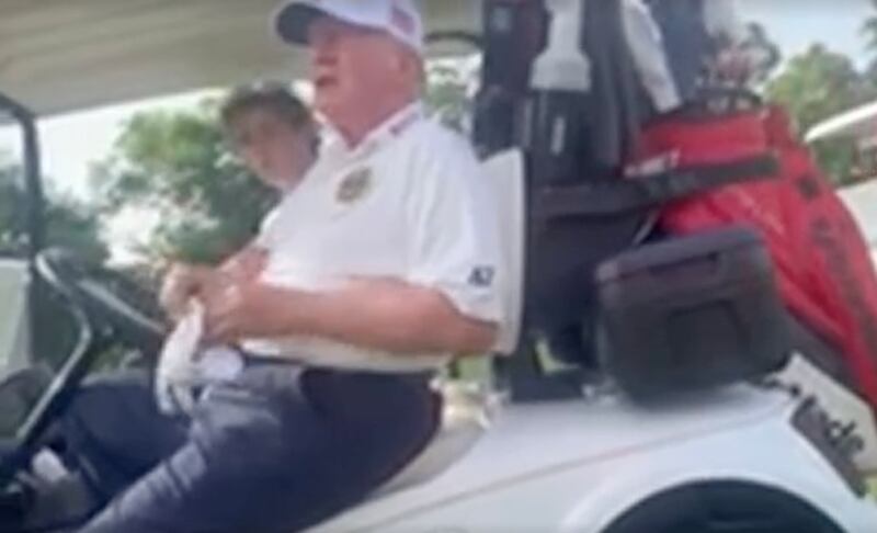 Trump sitting in a golf cart