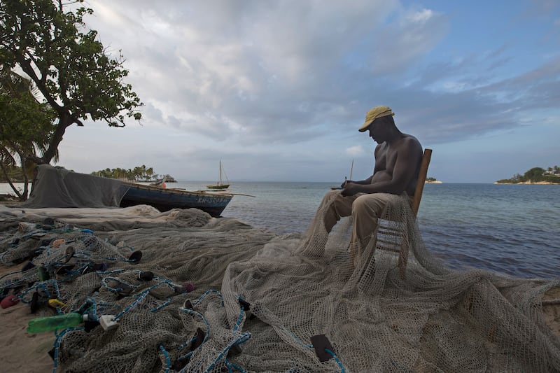 A picture of a fisherman mending his net in Ile-a-Vache