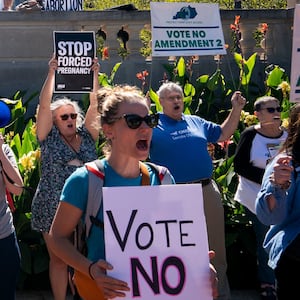 Protesters hold signs to vote no on Amendment 2, which would add a permanent abortion ban to Kentuckys state constitution