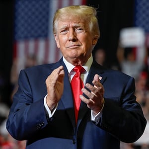 Donald Trump clapping his hands during a rally.