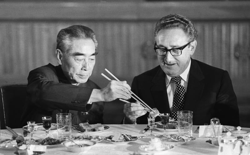 Secretary of State Henry Kissinger accepts food from Chinese Premier Zhou Enlai during a state banquet in the Great Hall of the People in Beijing.