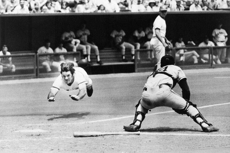 Pete Rose of the Reds dives into home plate past the glove of Giants’ catcher Dave Rader.