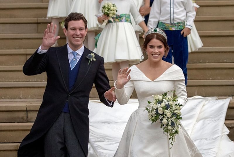 Princess Eugenie of York (R) and her husband Jack Brooksbank wave as they emerge from the West Door of St George's Chapel, Windsor Castle, in Windsor, on October 12, 2018 after their wedding ceremony.