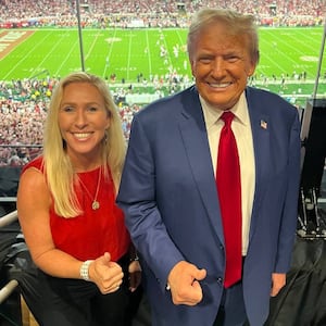 Marjorie Taylor Greene and Donald Trump pose together at an Alabama football game.