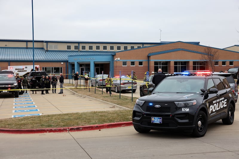 A police cruiser has its sirens on outside Perry High School.