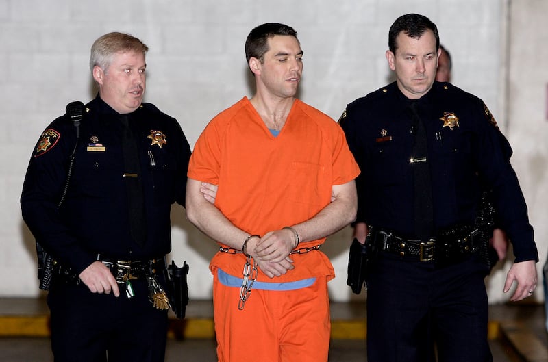 Scott Peterson is escorted by deputies as he wears an orange prison jumpsuit.