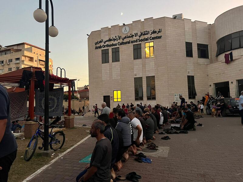 Hundreds of Palestinians taking refuge at a cultural center in Gaza City joining in a communal prayer.