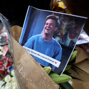 A memorial with flowers and a photo of the late actor Matthew Perry.