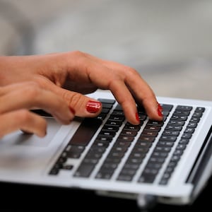 A person types on a laptop computer.