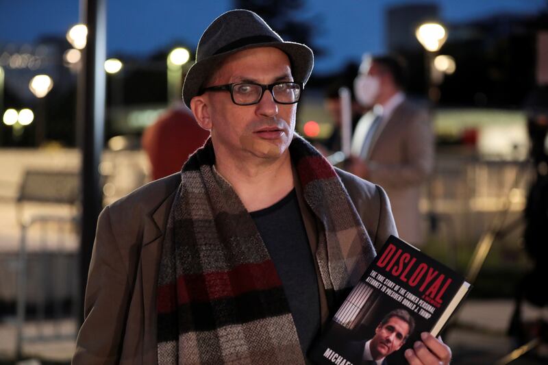 A man holds Michael Cohen's book "Disloyal"