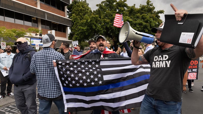 Bryce Henson (right) at a rally, wearing a shirt that says “Dad Army.”