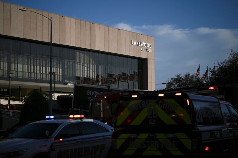 Cop cars sit outside Lakewood Church in Houston, Texas, with their emergency lights on.