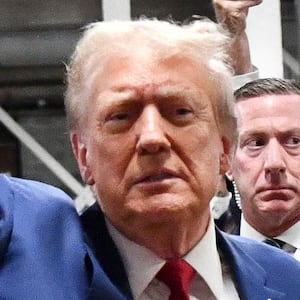 Donald Trump waves as he arrives at a college football game.