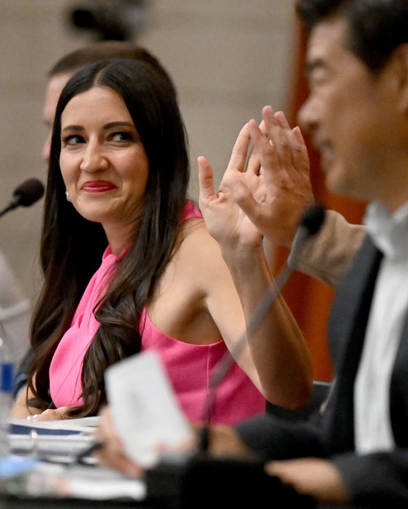 Chino Valley Unified School District President Sonja Shaw receives a high five from clerk Andrew Cruz, not pictured, as board member James Na, right, looks on