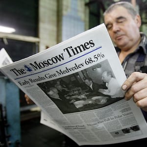 Man reads a copy of The Moscow Times newspaper