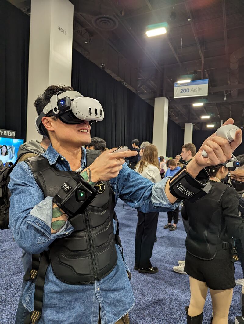 Tony Ho Tran shooting guns in virtual reality wearing bHaptics TactSuit. 