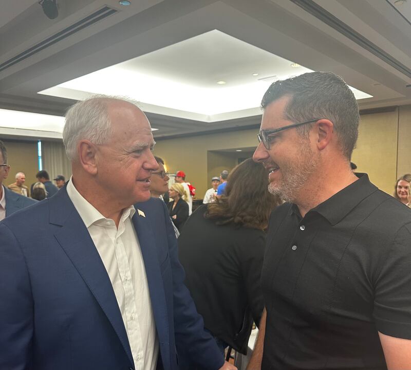 Minnesota Gov. Tim Walz greets his former student, Doug Vose, at a campaign event. 