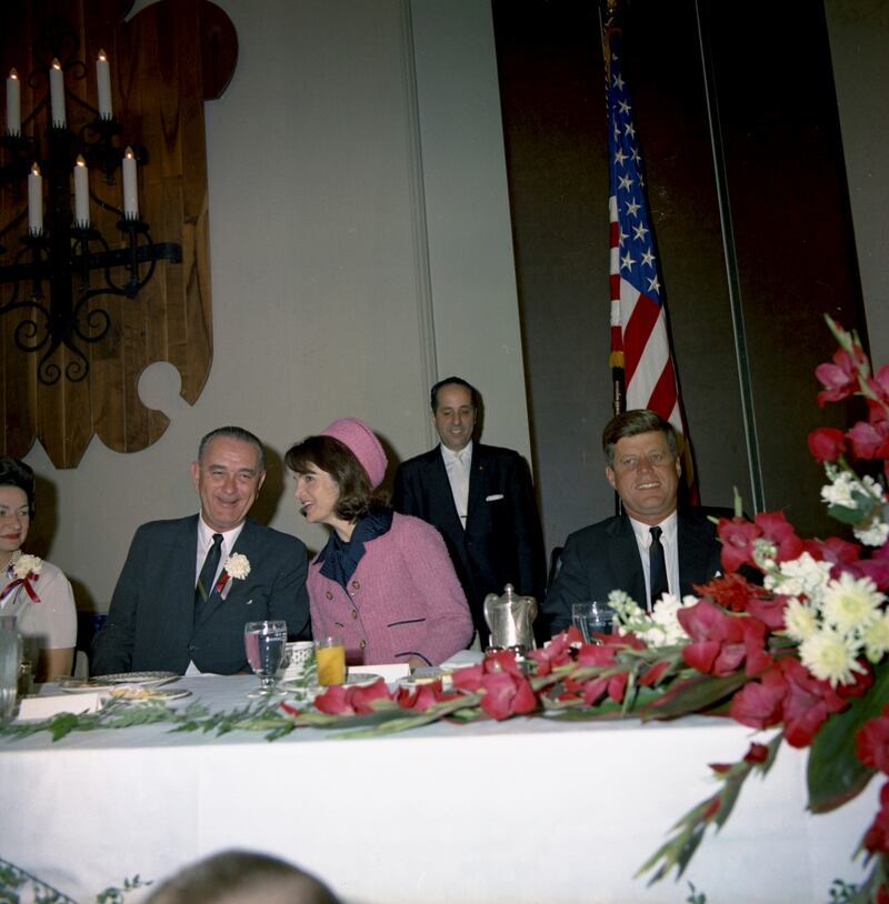 Former U.S. President John F. Kennedy (R) and first lady Jacqueline Kennedy (C) attend the Fort Worth Chamber of Commerce breakfast at the Hotel Texas in Fort Worth,Texas, in this handout image taken on November 22, 1963.