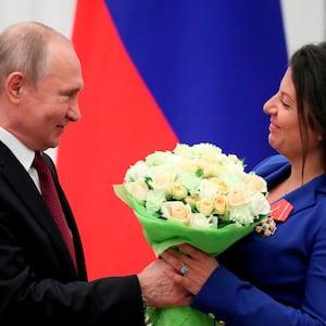 image: Margarita Simonyan receiving a bouquet of flowers from Vladimir Putin