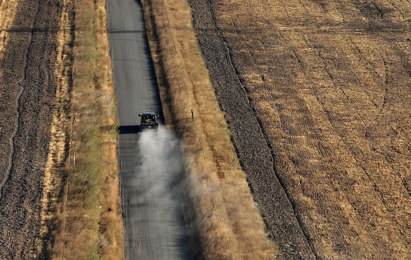 A car drives on a dirt road next to a parcel of land that was recently purchased near Travis Air Force Base by Flannery Associates.