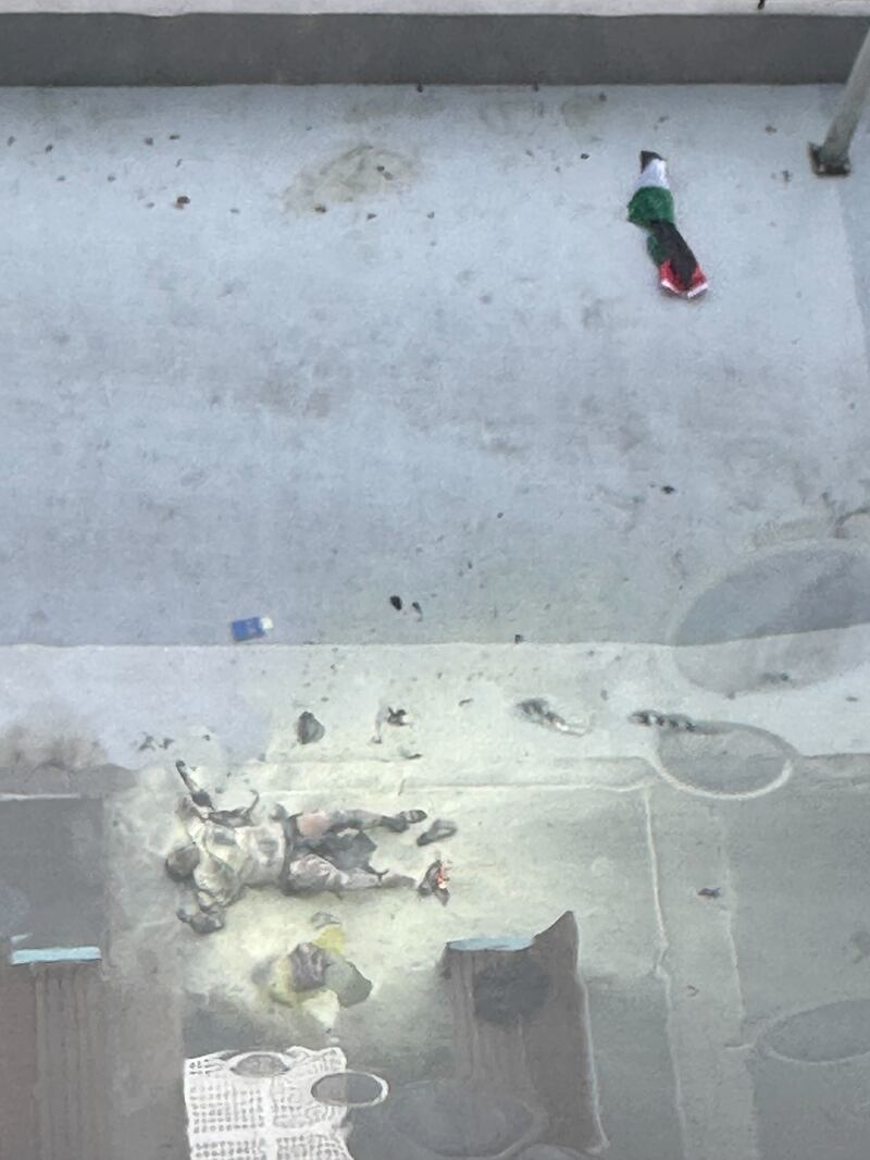  A woman lays on the ground near a Palestine flag after setting herself ablaze.