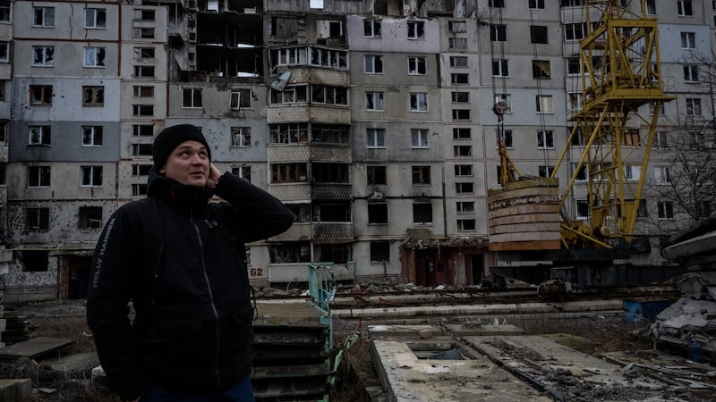 A Ukrainian man stands amid buildings that bore the brunt of Russian rocket and artillery attacks